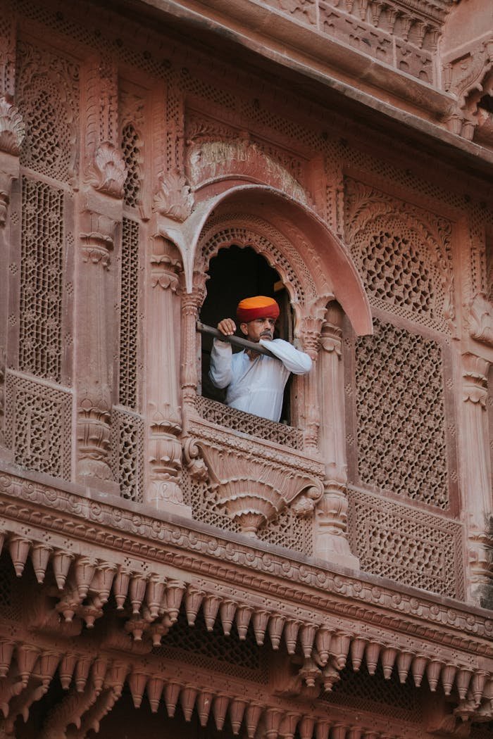 Explore the intricate details of a traditional Rajasthani facade with a man in traditional attire.