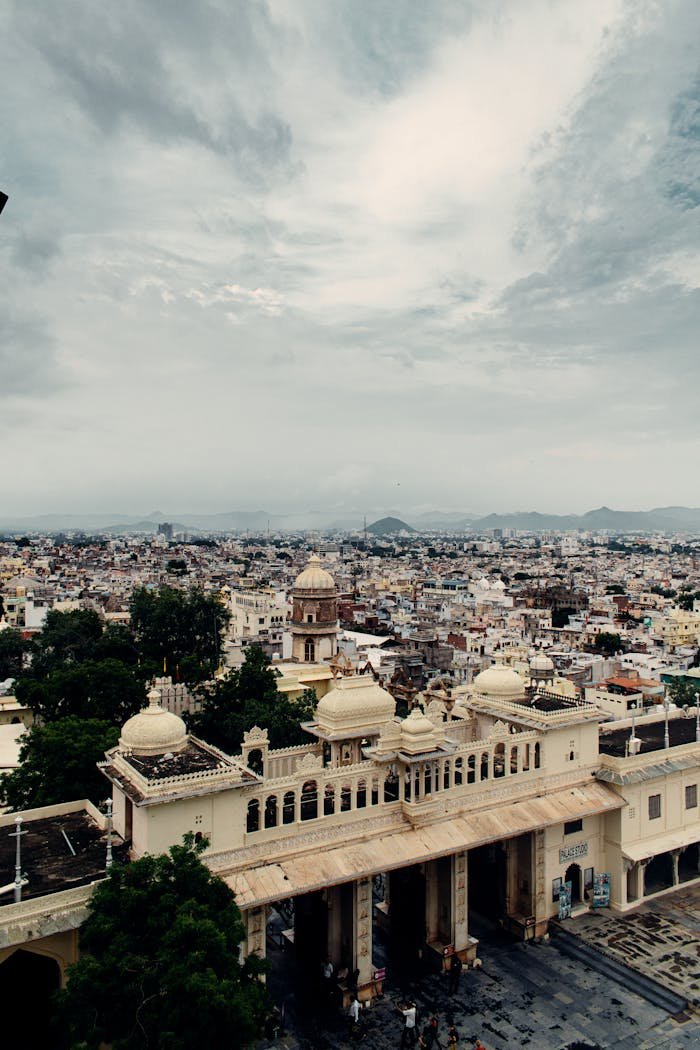 Explore the panoramic drone view of historical Udaipur with its iconic architecture under an overcast sky.